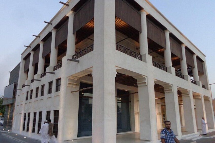 A multi-story building with a modern architectural design, featuring balconies and large windows. 5