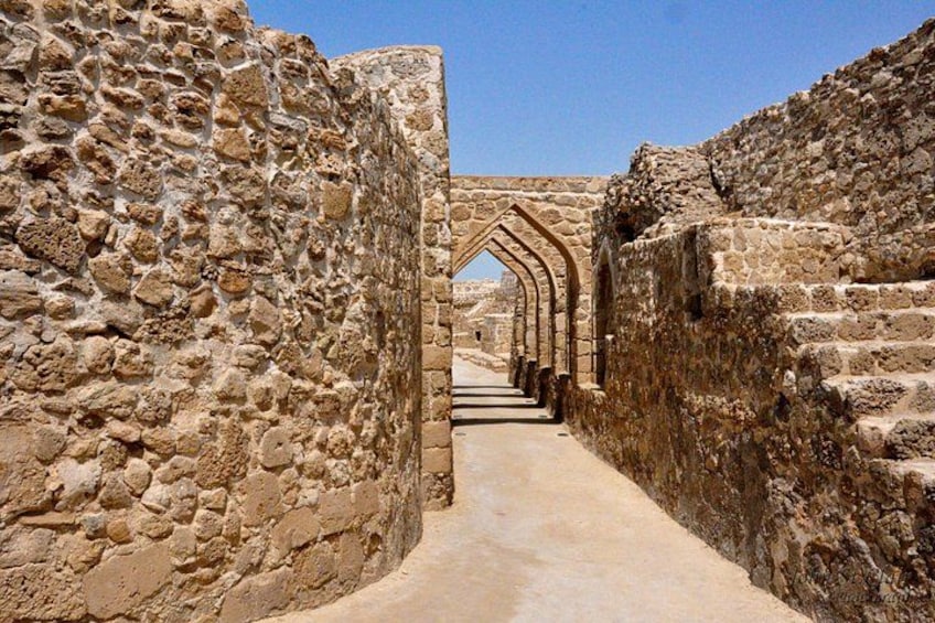 Un sendero de piedra antiguo que serpentea por un lugar histórico con estructuras de arco. 1