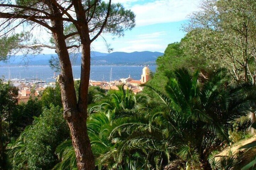 A coastal town with a prominent church, lush greenery, and a clear view of the sea. 2