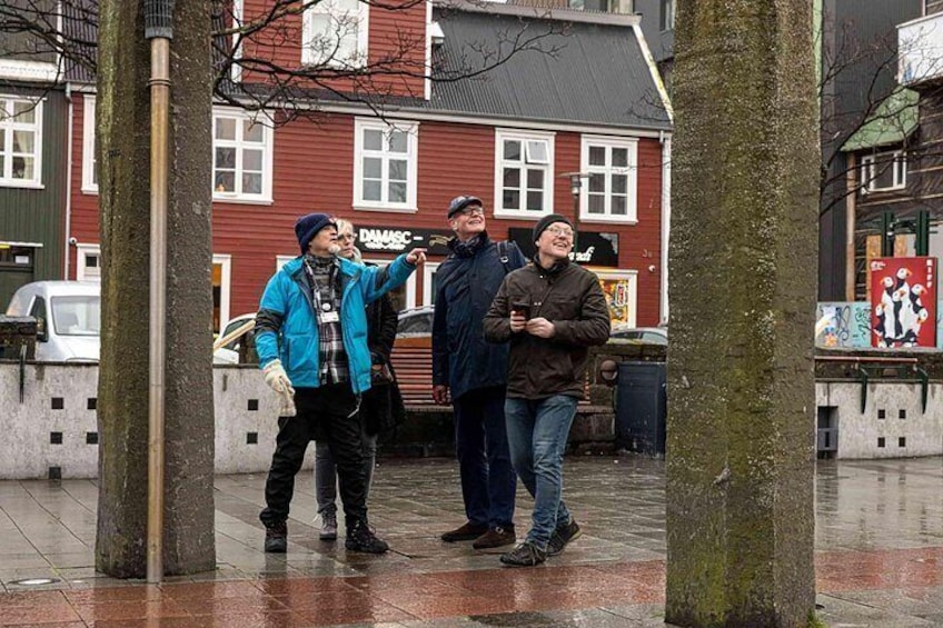Three people standing in a city square with buildings in the background. 4