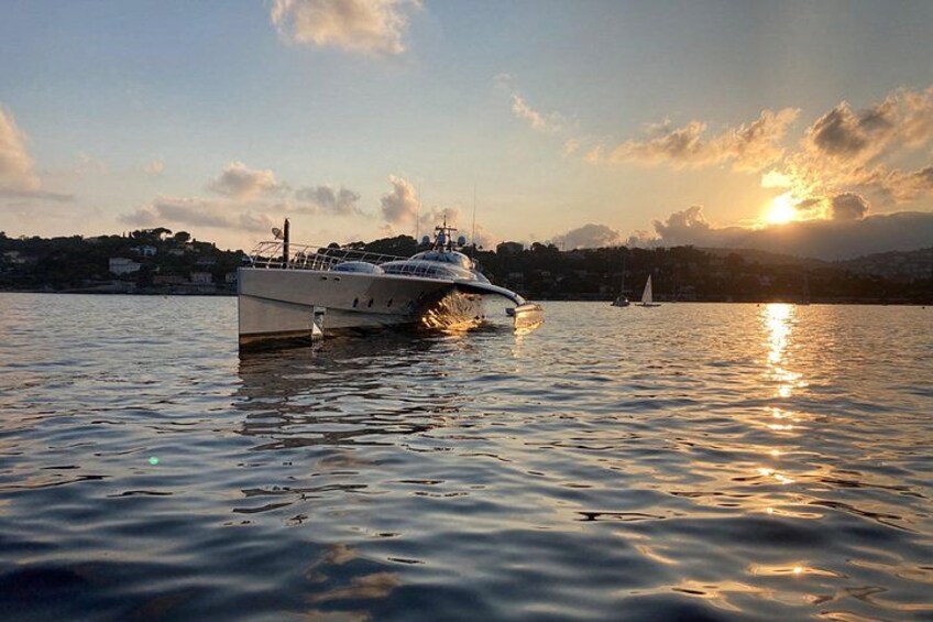 A yacht on calm water with a sunset in the background. 4