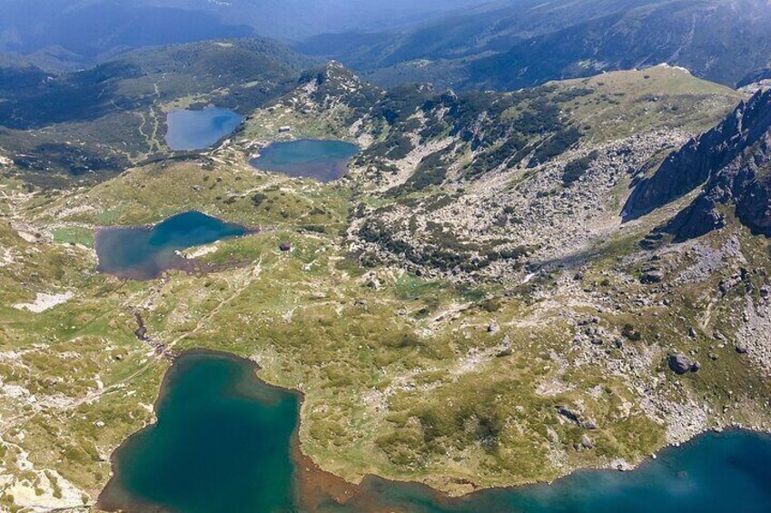 A mountainous landscape with several turquoise lakes and rugged terrain. 1