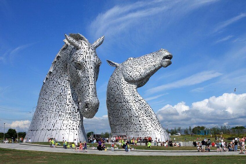 Les Kelpies, deux grandes turbines hydrauliques blanches, se dressent dans un parc où se promènent des gens. 2