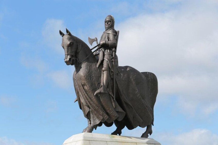 A statue of a person on a horse mounted on a pedestal. 1