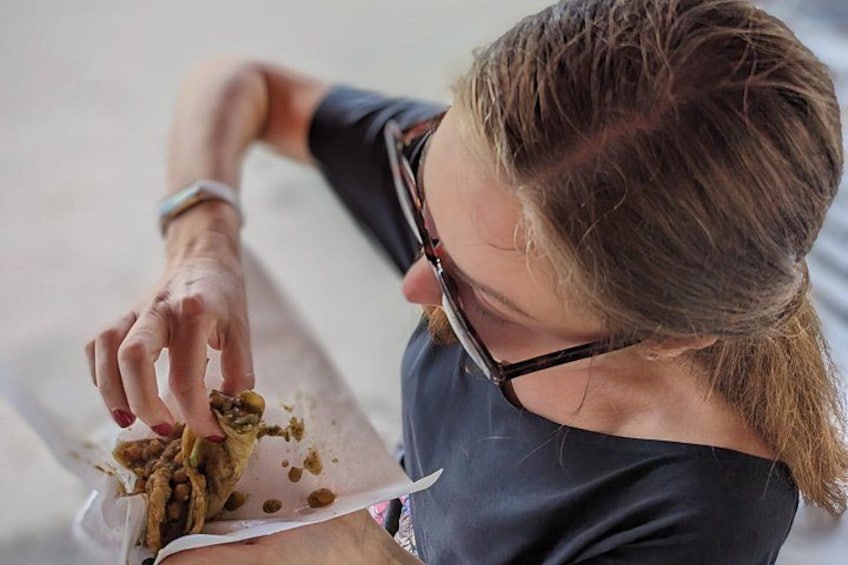 A person eating food from a paper plate. 1