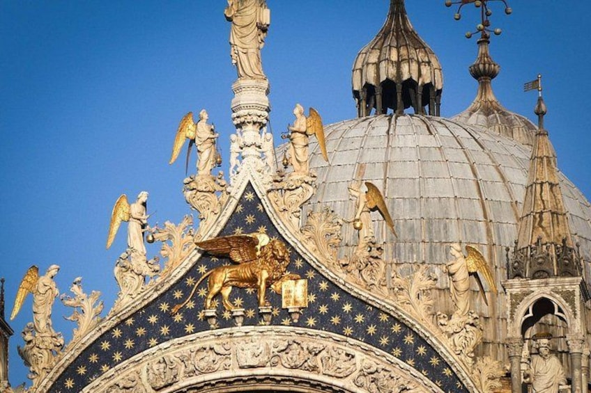 A domed building with ornate sculptures and golden accents. 4