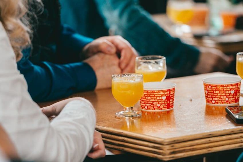 Une table en bois avec des boissons et des gobelets rouges ornés de texte blanc. 3