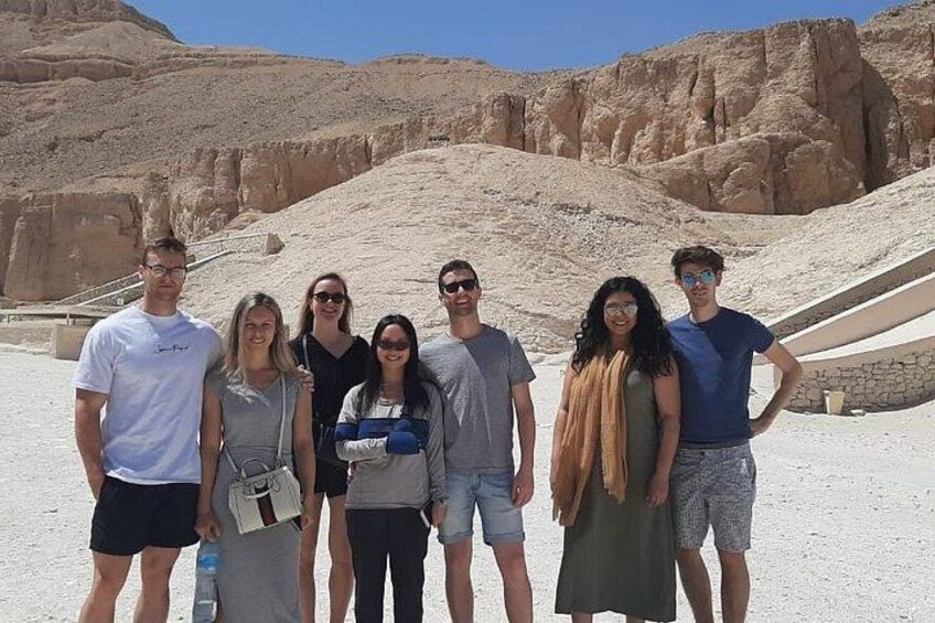 A group of people standing in front of a large, ancient pyramid. 2