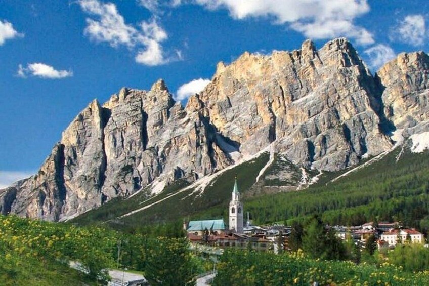 A mountainous landscape with a church and residential buildings. 2