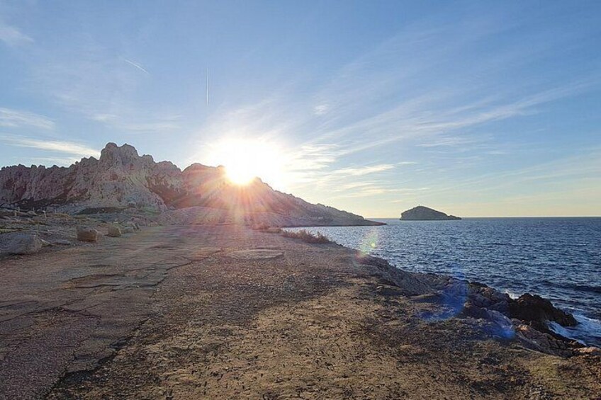 Une côte rocheuse, avec le soleil se couchant sur l’océan. 5