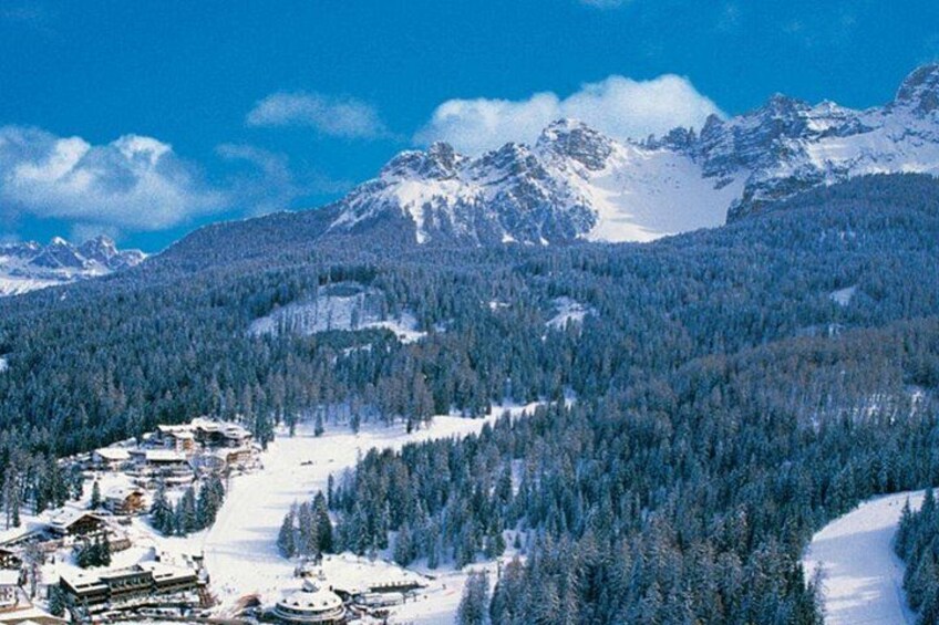 A snow-covered mountain landscape with a ski resort and a clear blue sky. 5