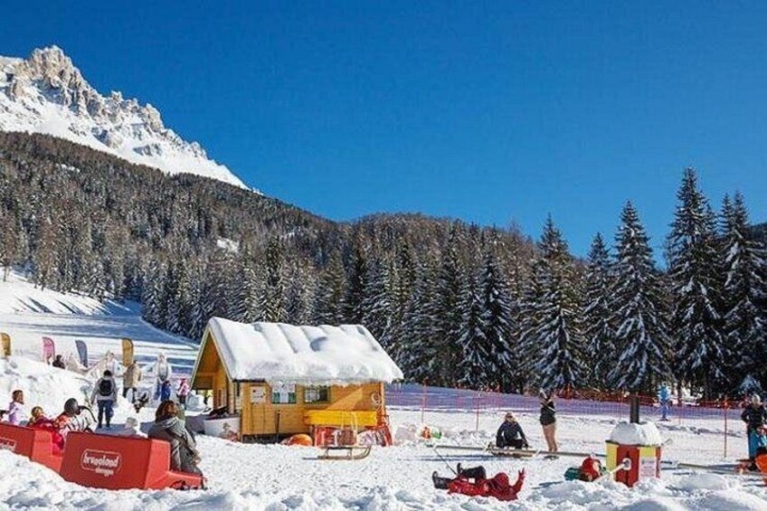 A snowy mountain scene with a wooden cabin, snow-covered trees, and a ski slope. 3
