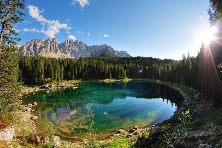 A clear lake surrounded by forest and mountains. 1