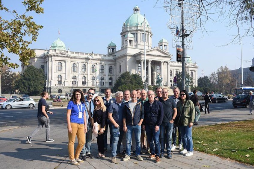 A group of people standing in front of a large, historic building with domed architecture. 3