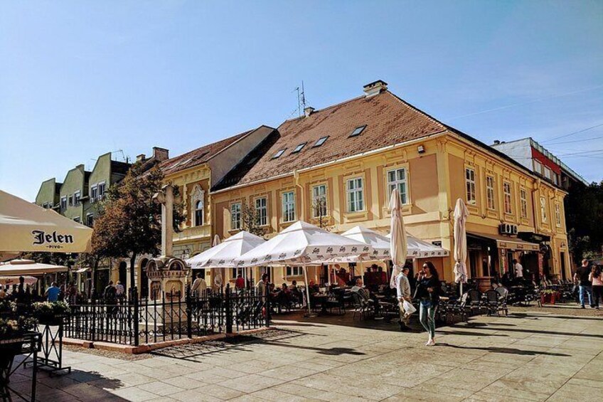 A historic building with outdoor seating, surrounded by pedestrians. 4