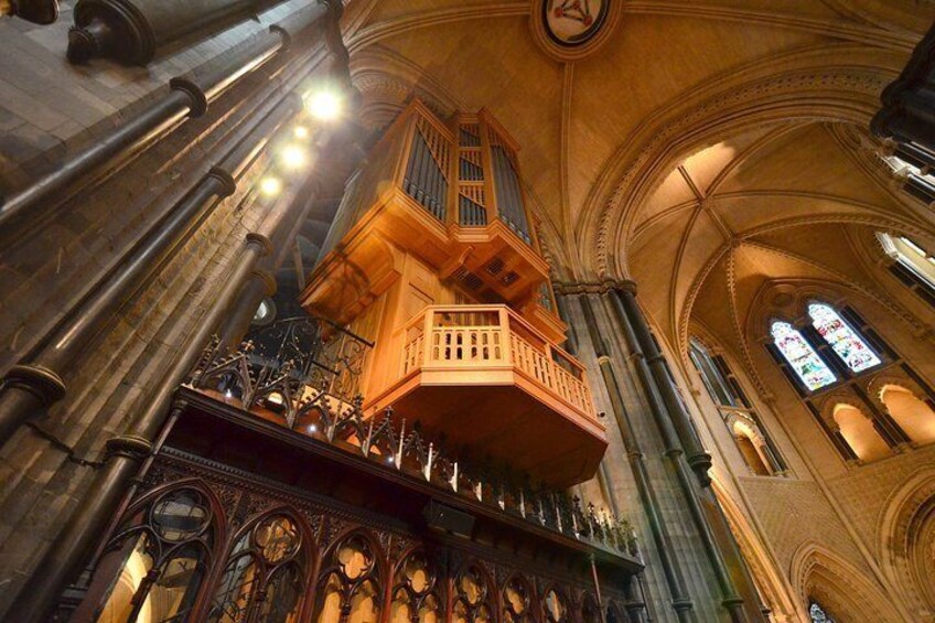 A grand organ with intricate carvings and a balcony. 1
