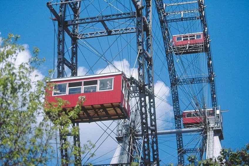Een rode kabelbaan hangt tussen twee hoge metalen torens, op een helderblauwe lucht. 2