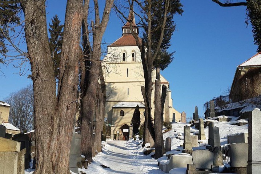 A church with a red roof, surrounded by snow-covered ground and bare trees. 3