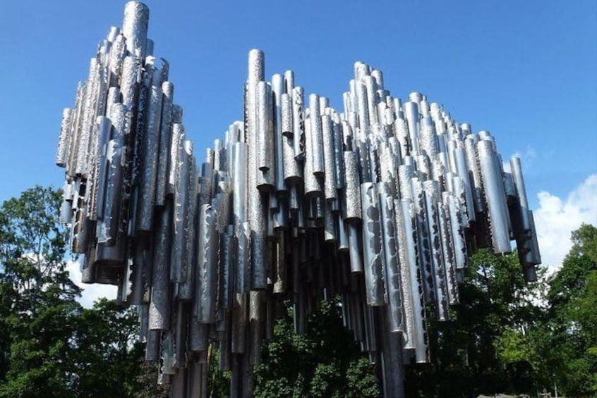 A metallic sculpture with cylindrical shapes and hanging elements. 2