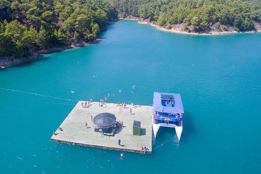 Eine schwimmende Plattform mit überdachtem Bereich und einem Boot, das am Rand liegt. 3