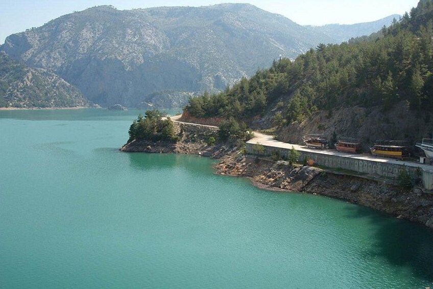 Ein Stausee mit einer Brücke, einem See und Bergen im Hintergrund. 5