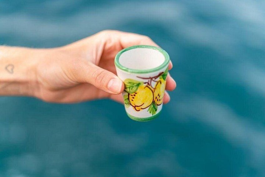 Une main tenant un petit récipient orné d’un motif représentant un citron. 2