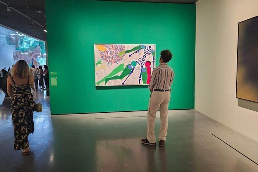 Et galleri med en grøn væg og et maleri. 4