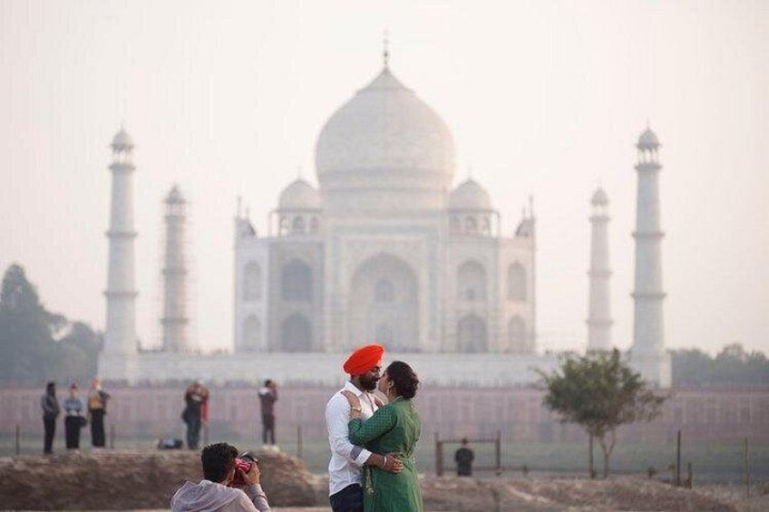 A couple embracing in front of the Taj Mahal. 3