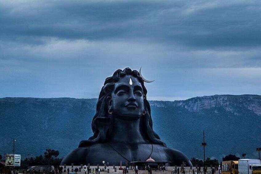 A large statue with a mountainous backdrop. 1