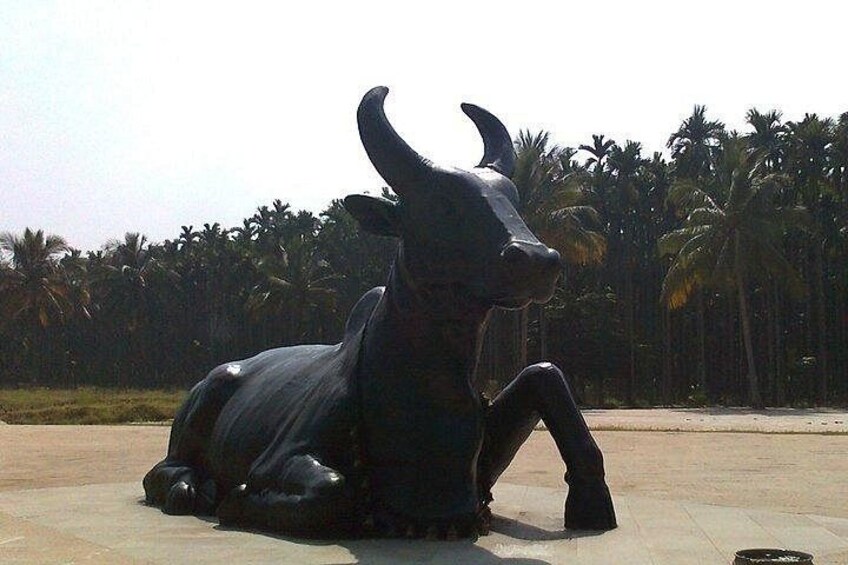 A large bull statue in a public square with palm trees in the background. 2