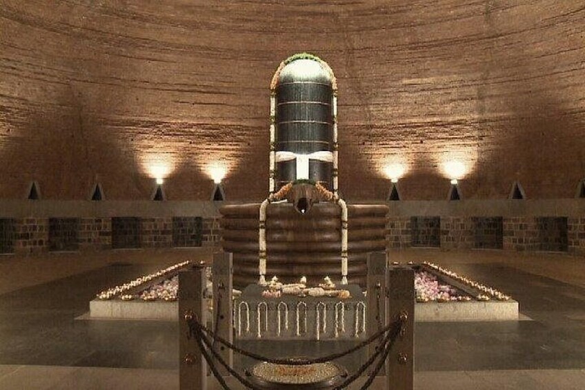 A large, cylindrical structure in a cavernous setting with stone walls and a central seating area. 5