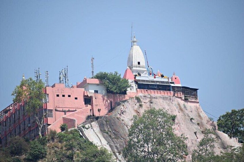 A temple on a hill with a red-roofed building and a white dome. 2