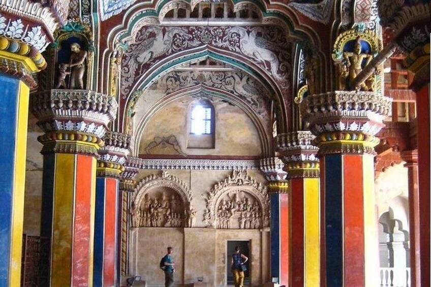 An ornate interior with detailed carvings, colorful columns, and a central arched doorway. 5