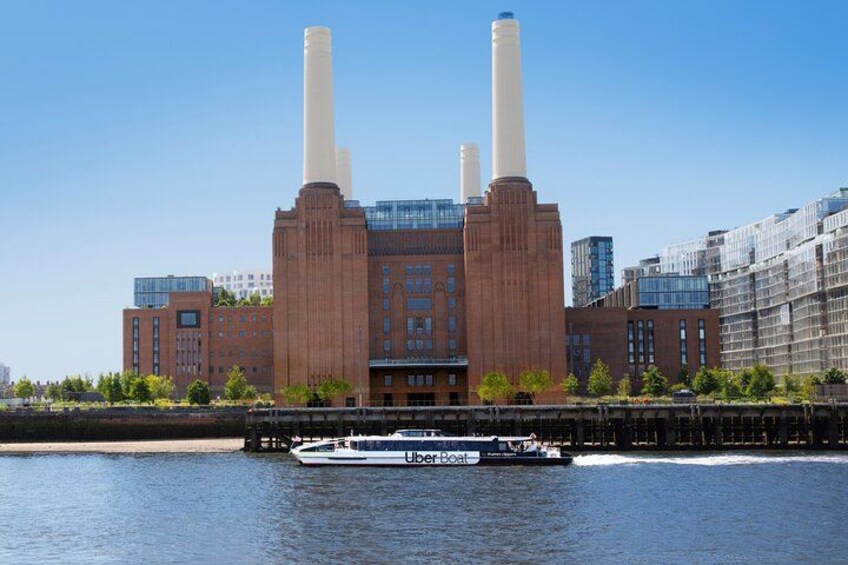 A large industrial building with three smokestacks, a river, and a boat. 4