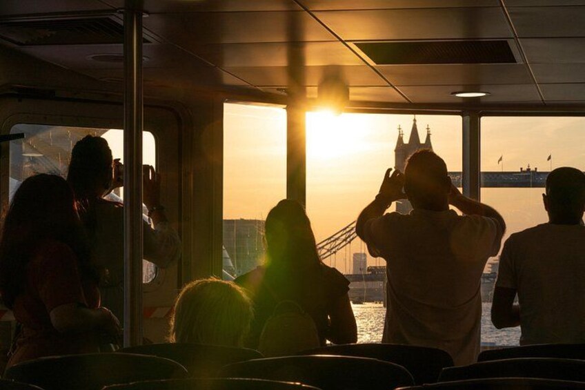 Een zonsondergang vanaf een boot, met een brug op de achtergrond. 2