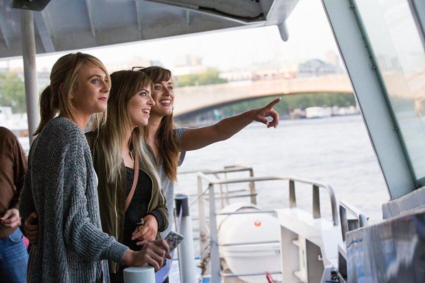 Trois personnes se trouvent sur un bateau, et l’une d’entre elles pointe du doigt en direction de la rivière. 3