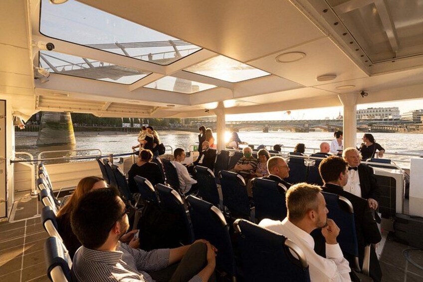 Un bateau avec des passagers à bord, une rivière et un pont en arrière-plan. 2
