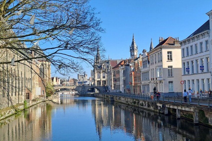 Een gracht met gebouwen, een brug en een klokkentoren. 3