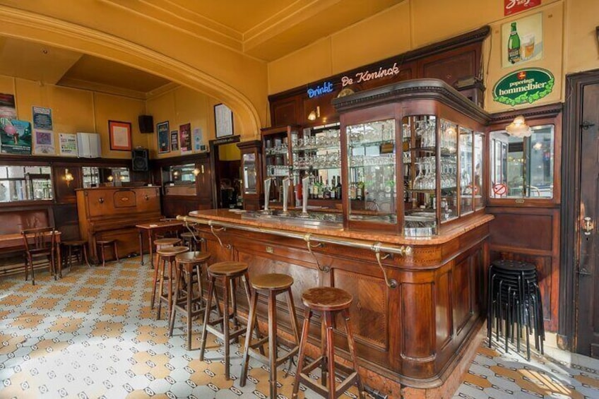 Un bar con taburetes de madera y una barra. 4