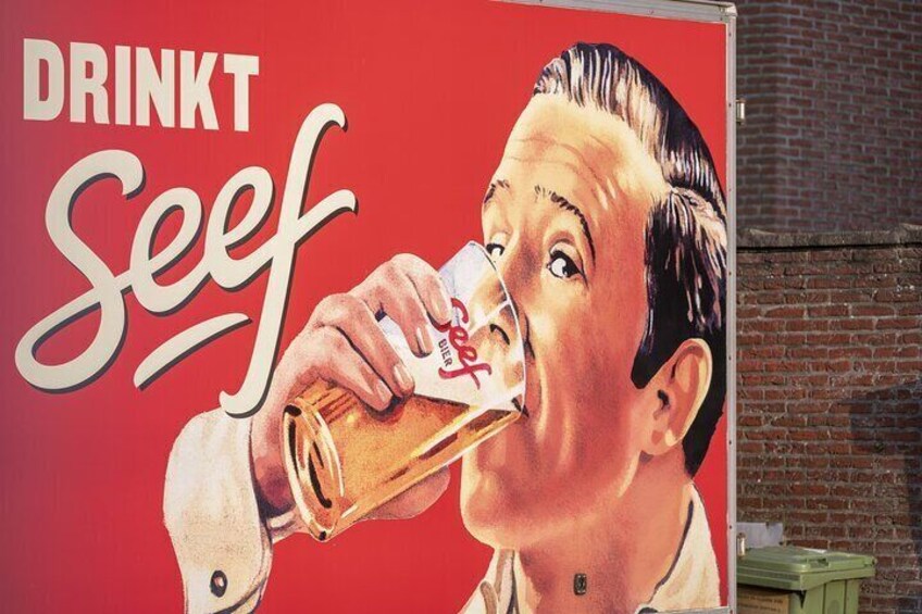Una persona bebiendo de una botella con fondo rojo y el texto "DRINKT Seef". 3