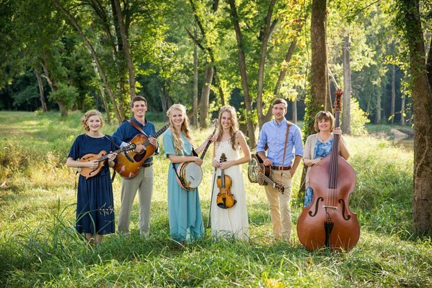 A group of people in a forest with musical instruments. 5