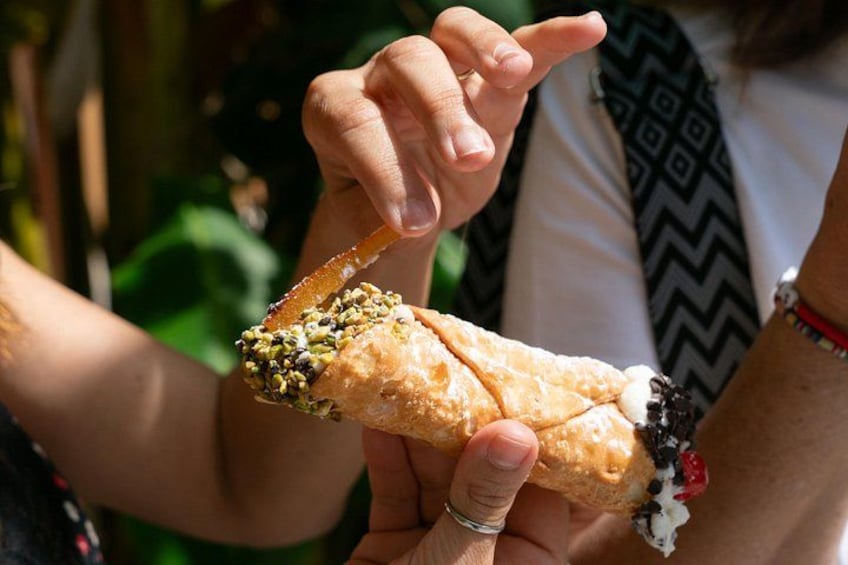 Une personne tenant une pâtisserie dont on peut voir la garniture. 3