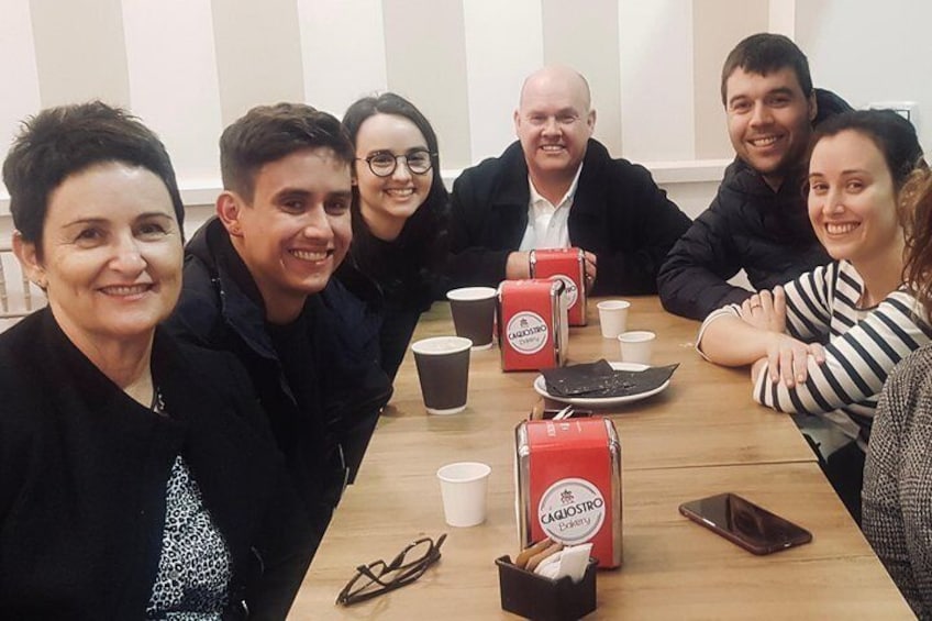 En gruppe mennesker sidder omkring et bord med kaffekopper og en smartphone. 5