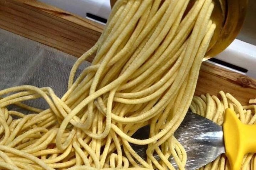A wooden sieve with pasta being drained. 3