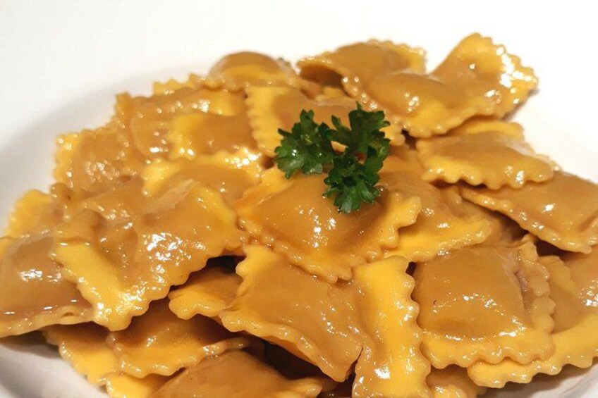A plate of ravioli with a garnish of parsley. 2