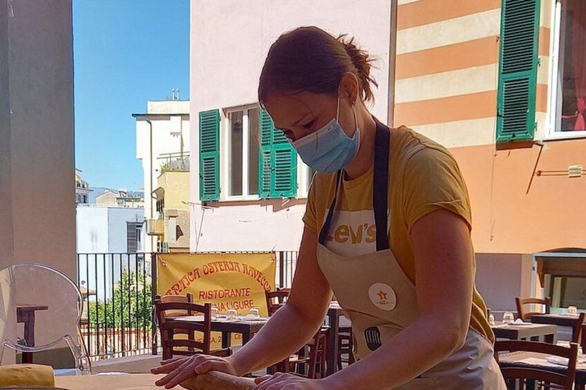 A person wearing a yellow shirt and an apron, working at a table with a yellow tablecloth. 5
