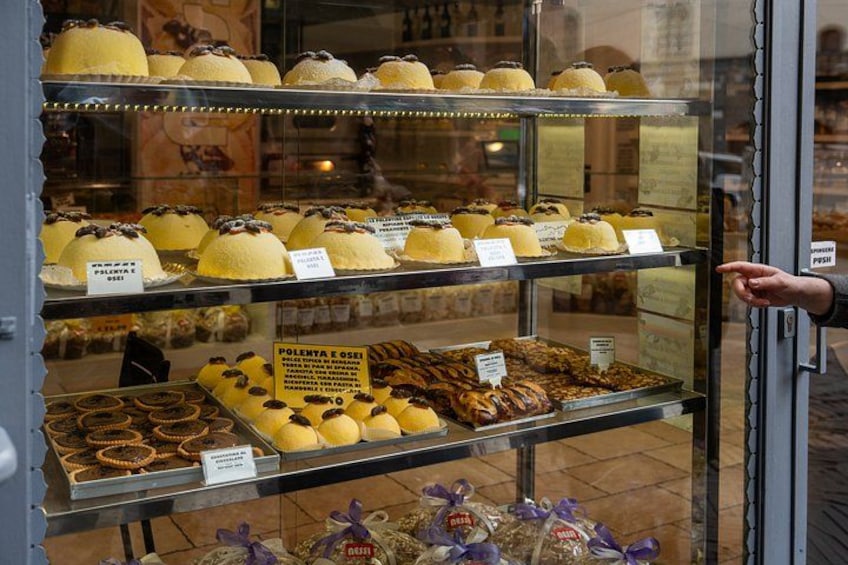 A bakery display case with various pastries and desserts. 2