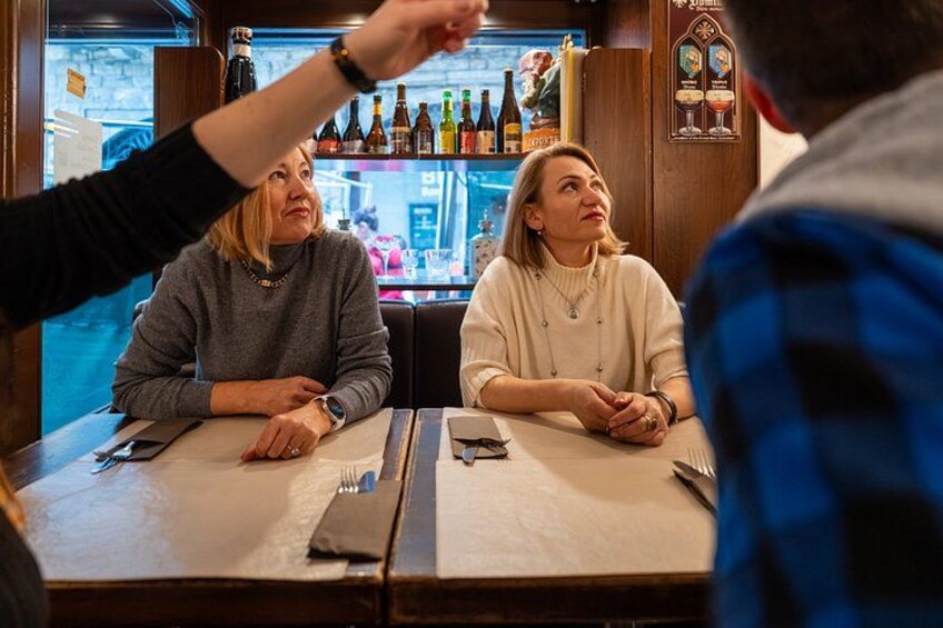 Een bar met flessen en een menukaart aan de muur. 2
