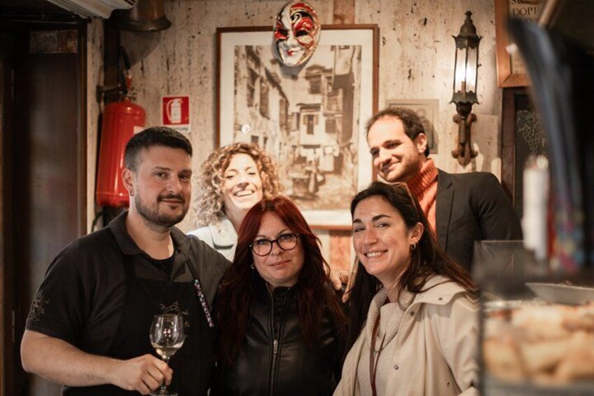 Un grupo de personas en una cafetería con un cartel antiguo y un extintor en la pared. 3