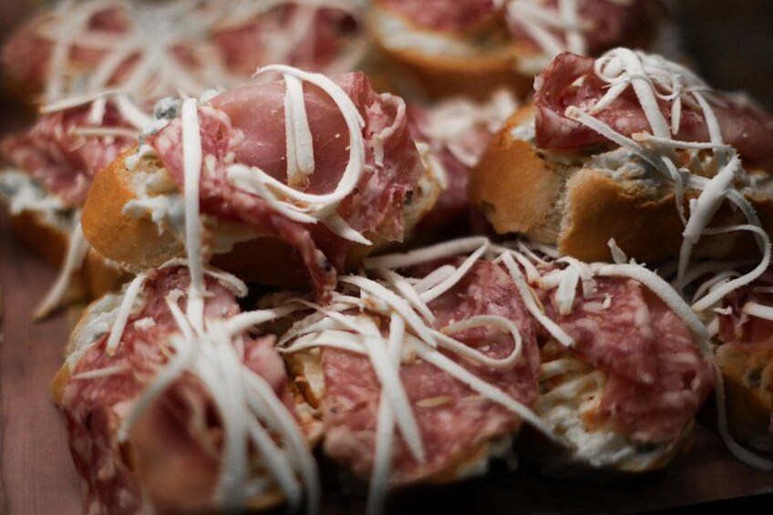 Un primo piano di panini guarniti con carne e formaggio. 5